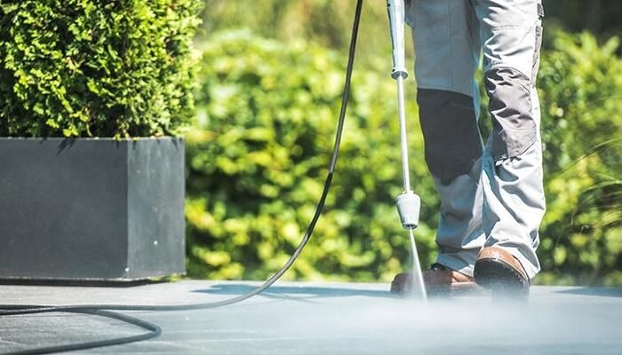 Professional pressure washing cleaning patio surface outdoors safely